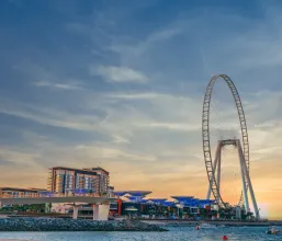 A ferris wheel against the backdrop of a beautiful sunset in Dubai.
