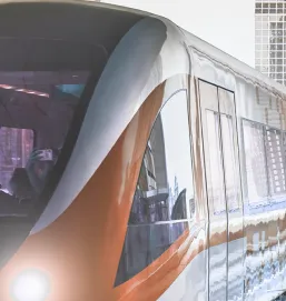 Front portion of a metro train with headlights on entering or leaving a station.