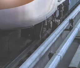 Close-up of the lower side of a metro train showing tracks and mechanical parts.