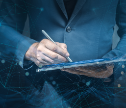 A man uses an iPad pen to input data on an iPad screen. Digital data floats around him, representing the high-tech and fast-paced environment of Dubai.